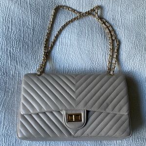 Cute beige/tan purse with adjustable straps.